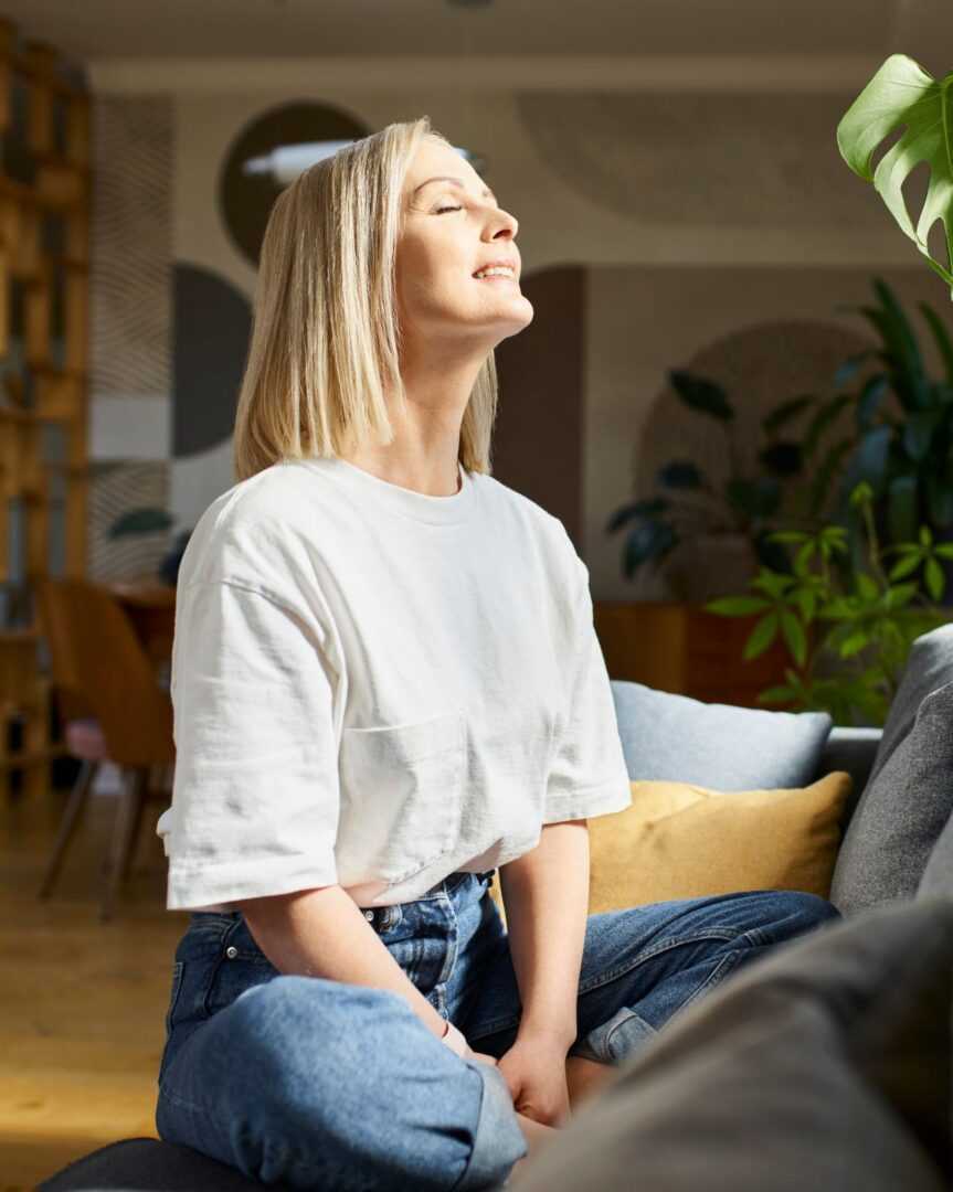 GettyImages-1427546676 A woman sitting on the ground with her eyes closed.