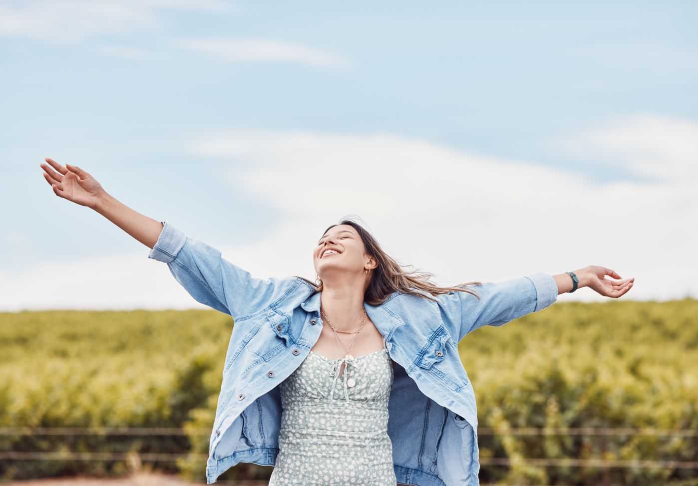 GettyImages-1485705128 A woman with her arms outstretched in the air.