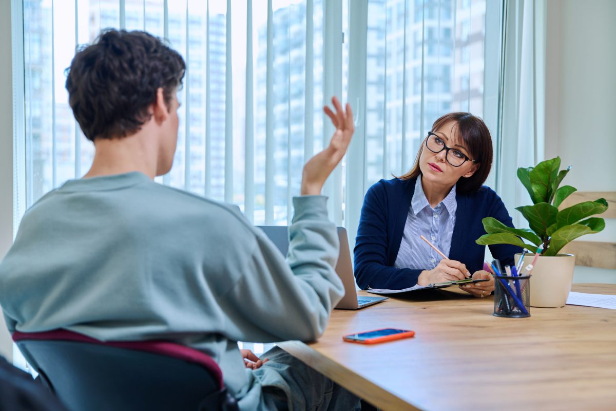 A man and woman sitting at a table talking.