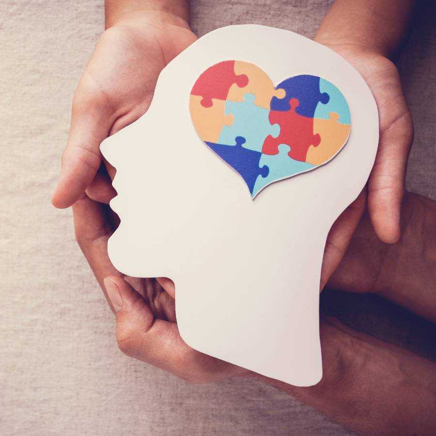 A person holding a puzzle heart in their head.